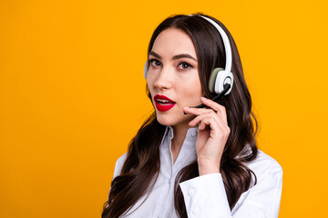 Young businesswoman with headset on vibrant yellow background, confidently representing customer...