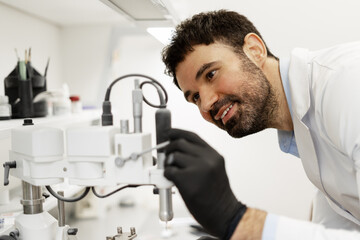 Prosthetic technician working on a milling machine for dental prostheses