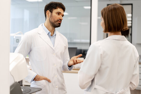 Medical professionals discussing in laboratory wearing lab coats