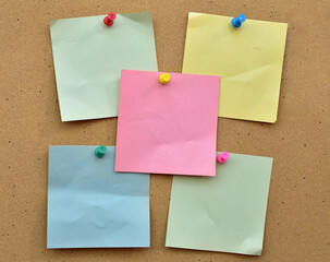 Colorful notes on a cork wall with a pin