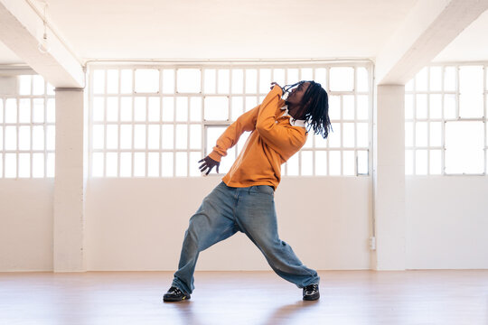 Hip-hop black male dancer wearing colorful urban streetwear dancing