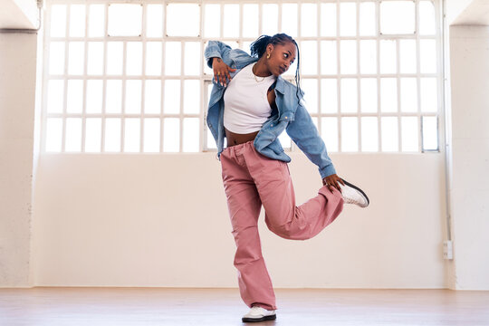 Hip-hop female dancer wearing colorful urban streetwear dancing - Powered by Adobe