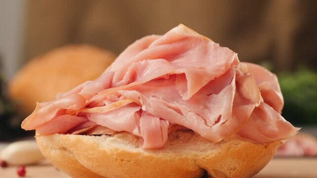 Mortadella ham sandwich, Traditional italian focaccia filled with thin pesto slices of mortadella, served by chef man in cafe restaurant. Macro of traditional italian spanish tapas antipasti. 