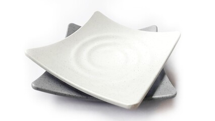 Stack of empty square white and grey plates with ceramic melamin material isolated on white background