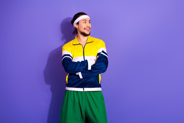 Young sporty man in retro outfit smiling and standing confidently against a vibrant violet background
