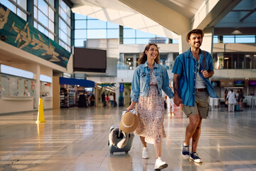 Happy couple of travelers at airport.