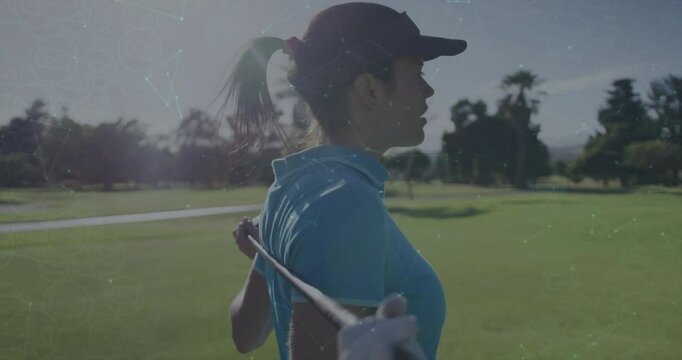 Mature woman golfer holding golf club behind shoulders stretching back rotating torso for warmup