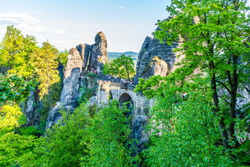 A view past trees towards the Bastei bridge above the River Elbe in Saxon Switzerland, Germany in...