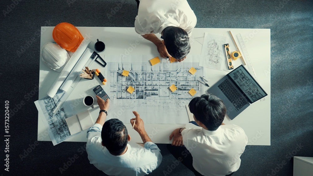 Poster top down aerial view of interior designer writing at sticky note while planning design with engineer