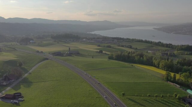 Aerial view of lake and mountains surrounded by fields, Switzerland.