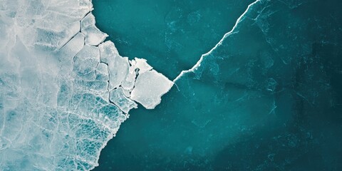 Fractured white ice with visible diagonal line on teal background surface
