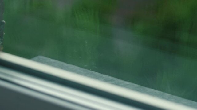 heavy rain outside the window on a summer day, raindrops falling on the cornice outside the window during bad weather, rainy season outside the window
