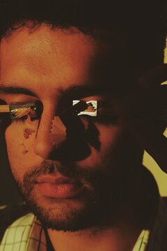 Man crying with pencil sharpener on face in sunset lighting #3