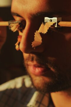 Man crying with pencil sharpener on face 