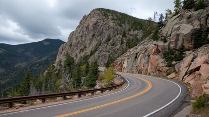 Winding mountain road curves around a rocky cliffside, trees and cloudy sky in the background