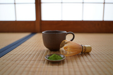 Serene Matcha Tea Ceremony:  Earthy Mug, Bamboo Whisk, and Powder on Tatami Mat.