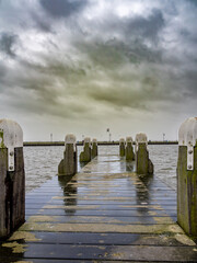 Wooden pier in the sea on a stormy day in Volendam (Netherlands)