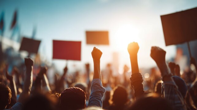 Supporters cheering with banners at political rally during golden hour