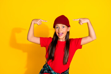 Delightful young girl wearing casual fashion posing with gesturing hands against vibrant yellow background showing excitement