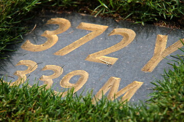 A distance marker sign plaque  on a golf course 