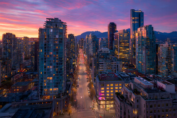 Vancouver cityscape showing granville street at sunset with mountains in background