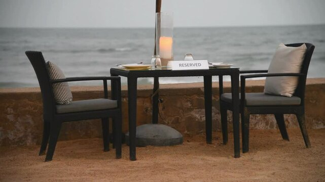 A reserved table awaits diners on a tranquil beach setting