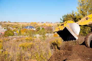 Yellow bulldozer at a construction site. Big wheel excavator leveling and clearing the land plot...