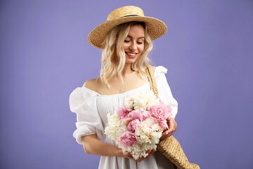 Happy woman with bouquet of beautiful peonies on purple background