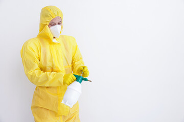 Pest control worker in protective suit spraying insecticide near white wall. Space for text