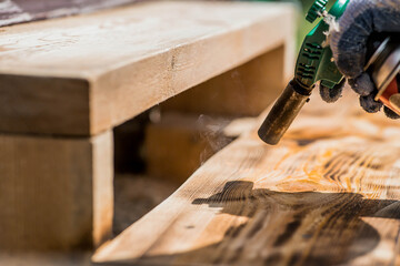The process of burning wooden boards with a burner. The texture of wood treated with fire from a...