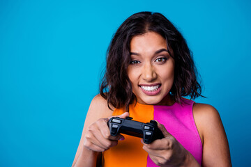 Young fashionable woman holding a game controller with an expressive look on a colorful vibrant...
