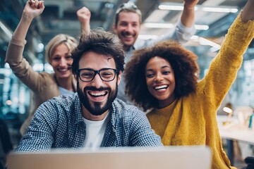 group of young people cheering while watching at laptop