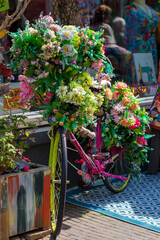 Old vintage woman bicycle decorated with pink flowers on small bridge in old part of Deventer. High quality photo