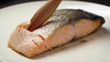 Salmon Delight: A delectable, expertly cooked salmon fillet rests invitingly on a pristine plate, its flaky texture and rich color offering a promise of culinary satisfaction.