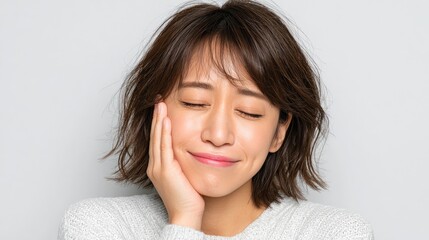 Smiling woman with closed eyes touching her cheek