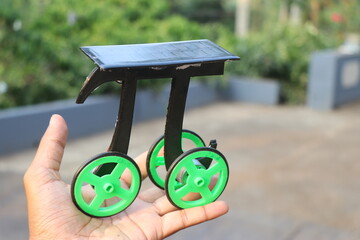 Small solar powered car or eco friendly car held in the hand. Solar cell vehicle built at home