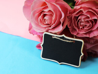 Wooden price tag and pink roses. Flower shop.