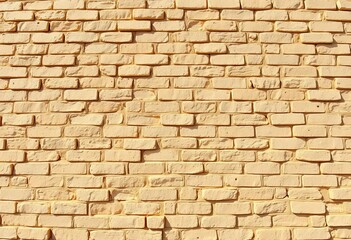 Fototapeta premium Ancient cream, beige, yellow-brown brick wall texture, vintage seamless design, bathed in natural light, design, pattern