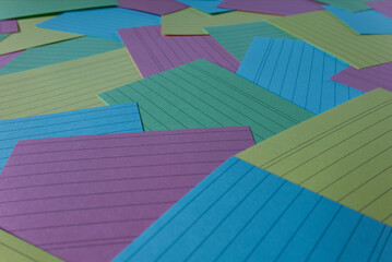 Colorful lined index cards are scattered across a surface, creating a vibrant and organized...