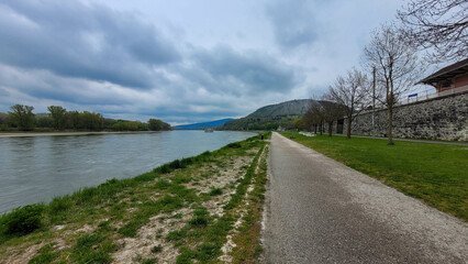 Pathway Along Danube Riverbank with Historic Wall in Hainburg, Austria
