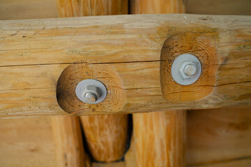 Close-up of wooden beams with embedded metal bolts showing secure joinery and traditional carpentry...
