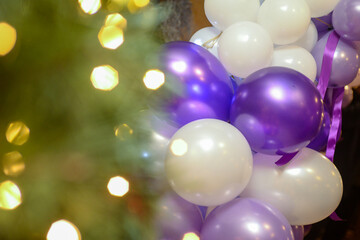 A photo backdrop made of blue and white balloons and a curtain made of small light fixtures