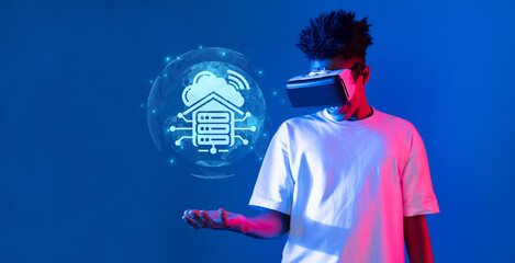 A young man interacts with a virtual reality headset, surrounded by holographic elements...