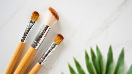 Wooden Makeup Brushes on White Towel with Green Leaf