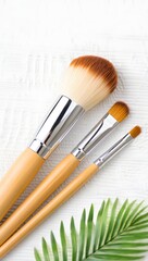 Wooden Makeup Brushes on White Towel with Green Leaf
