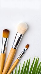 Wooden Makeup Brushes on White Towel with Green Leaf