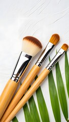 Wooden Makeup Brushes on White Towel with Green Leaf