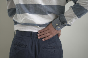 Young asian businessman suffering headache, backache and neck pain while working for so long,...