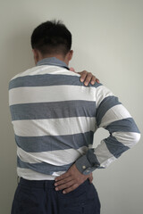 Young asian businessman suffering headache, backache and neck pain while working for so long,...