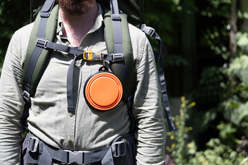 Outdoor enthusiast wearing a hiking backpack with a portable dog water bowl attached. Perfect concept for adventure, preparedness, and pet-friendly travel. Copy space